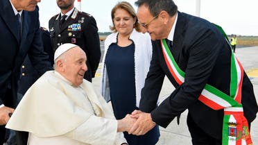 Pope Francis shakes hand ahead of his visit to Portugal for World Youth Day 2023 at Fiumicino airport in Rome, Italy, on August 2, 2023. (Reuters)         