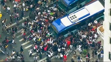 In this image taken from video provided by WABC-TV, a crowd pushes up against a public transit bus as it attempts to move through Union Square, Friday, Aug. 4, 2023, in New York. (AP)