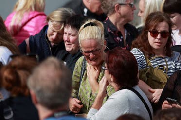 Sinead O'Connor fan, Ruth O'Shea, centre, stands outside the former home of Sinead O'Connor ahead of the late singer's funeral, in Bray, Co Wicklow, Ireland, Tuesday, Aug. 8, 2023. (AP)