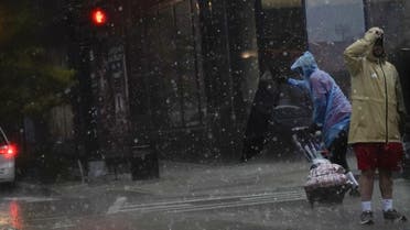 An umbrella is blown inside out as a person crosses the street during a storm in Washington, DC, on August 7, 2023. (AFP)