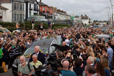 Fans of Sinead O'Connor line the street as her funeral cortege passes through her former hometown of Bray, Co Wicklow, Ireland, Tuesday, Aug. 8, 2023. (AP)