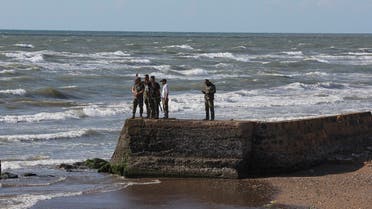 Military personnel stand near the sea shore following the sinking of a migrant boat off the Syrian coast after sailing from Lebanon, as pictured from the Lebanese-Syrian border crossing in Arida, Lebanon, on September 23, 2022. (Reuters)