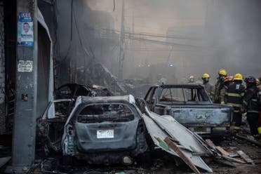 Firefighters work next to destroyed vehicles after a powerful explosion in San Cristobal, Dominican Republic, Monday, Aug 14, 2023. (AP)