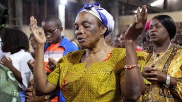 A faithful of the parish of St Charles prays as she attends the morning mass officiated by Abbey Victor Ntambwe, during which he sensitizes people to participate in the electoral process, in Kinshasa, Democratic Republic of Congo, January 22, 2023. (Reuters)