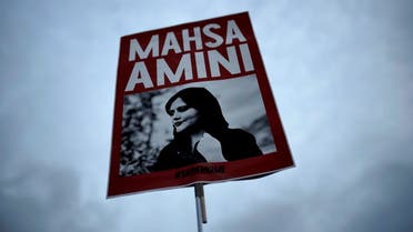 A woman holds a placard with a picture of Iranian Mahsa Amini as she attends a protest against her death, in Berlin, Germany, September 28, 2022. (AP)