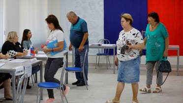 Voters walk toward members of an electoral commission to receive their ballots at a polling station during local elections held by the Russian-installed authorities in the course of Russia-Ukraine conflict in Donetsk, Russian-controlled Ukraine, September 8, 2023. (Reuters)