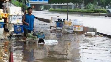 A man stands on a flooded road in Hong Kong on September 8, 2023. (AFP)             