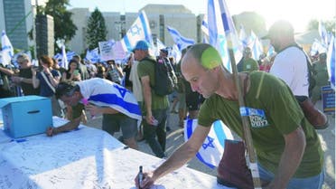 Reserve soldiers sign a declaration of refusal to serve in Tel Aviv last July (AP)