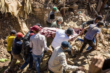 Volunteers recover a body from the rubble of collapsed houses in Tafeghaghte, 60 kilometers (37 miles) southwest of Marrakesh, on September 10, 2023, two days after a devastating 6.8-magnitude earthquake struck the country. (AFP)