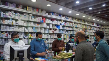 Pharmacy employees wearing facemasks as a preventive measure against the COVID-19 coronavirus attend to customers in Islamabad on March 23, 2020. (AFP/File)
