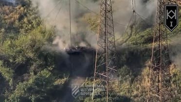  A soldier evacuates from a Russian armored vehicle purportedly shot by Ukrainian drone near Andriivka, Donetsk region, Ukraine in this still image obtained from video released on August 22, 2023. (Reuters)