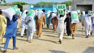 Pakistani flood affectees can be seen taking King Salman Humanitarian Aid and Relief Centre (KSrelief) food packets and relief items