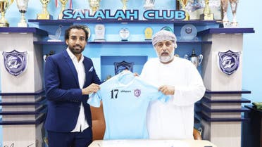 Pakistan footballer Saddam Hussain (left) takes picture with an official of Salalah Club after signing a contract with the club on September 17, 2023. (@SaddamSH17/Twitter)