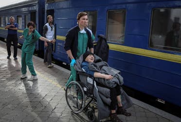 Medical workers take a patient into a specially equipped train, run by Medicins Sans Frontieres (MSF) in collaboration with Ukraine's Ministry of Health and National Railways, to evacuate wounded people from war-affected areas of eastern Ukraine, amid Russia's invasion of the country, in Dnipro, Ukraine May 10, 2022. (Reuters)