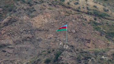 This photograph taken from the Armenian side of the border near the town of Kornidzor, on September 23, 2023, shows an Azerbaijan flag on the Azerbaijan side of the border near the Lachin corridor. (AFP)