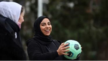 Two hijab-wearing girls playing football
