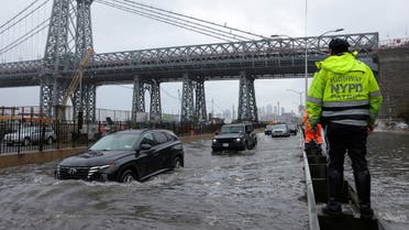 A police officer from the NYPD Highway Patrol looks to motorists drive through a flooded street after heavy rains as the remnants of Tropical Storm Ophelia bring flooding across the mid-Atlantic and Northeast, at the FDR Drive in Manhattan near the Williamsburg Bridge, in New York City, US, September 29, 2023. (Reuters)