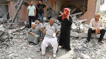 Palestinians watch the civil defense team as they search for victims trapped under the rubble of a house destroyed during Israeli strikes, in Khan Younis, in the southern Gaza Strip, October 8, 2023. (Reuters)
