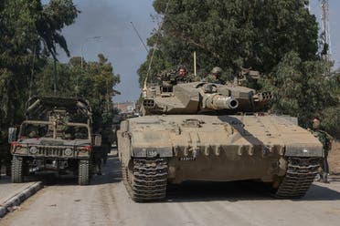 Israeli tanks leave the kibbutz of Kfar Aza in southern Israel after inspecting the area on the border with the Gaza Strip, on October 10, 2023. (AFP)