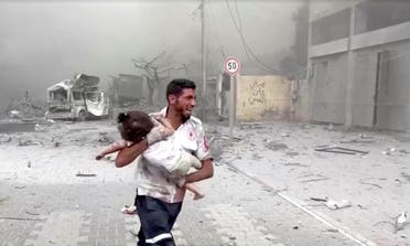 A medic runs as he carries an injured Palestinian child to ambulance in this screengrab taken from a video, in Gaza, October 9, 2023. (Reuters)
