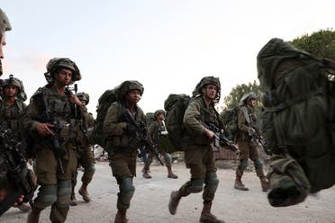 Israeli soldiers gather following a mass infiltration by Hamas gunmen from the Gaza Strip, in Kibbutz Beeri in southern Israel, October 11, 2023. (Reuters)