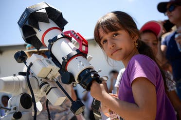 A youngster looks on as people gather to observe the solar eclipse in Neiva, Colombia, on October 14, 2023. (Reuters)
