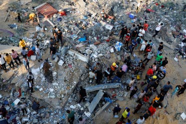 Palestinians search for casualties under the rubble of a house destroyed in Israeli strikes in Khan Younis in the southern Gaza Strip October 16, 2023. (Reuters)