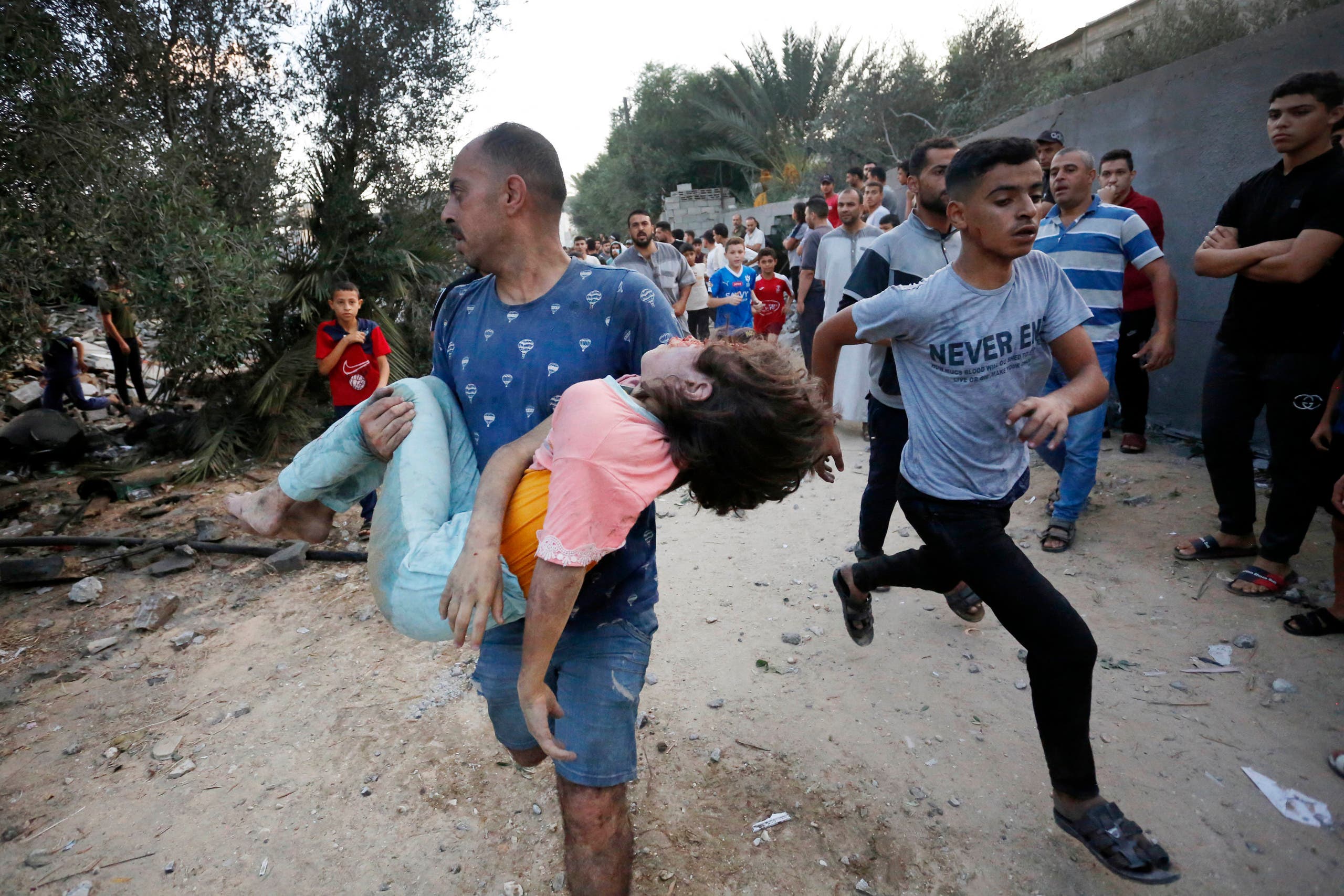 محاولة إسعاف الأطفال الجرحى جراء الغارات الإسرائيلية على غزة - فرانس برس