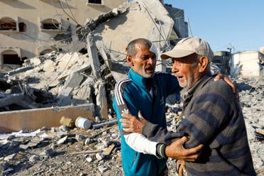 El palestino Mohammad Abu Daqa, que sobrevivió a los ataques israelíes que mataron a 8 miembros de su familia y aún busca a otros tres que aún están atrapados bajo los escombros de su casa, reacciona con un familiar frente a las ruinas en Khan Younis, en el sur de la Franja de Gaza. Octubre 15 de septiembre de 2023. (Reuters)