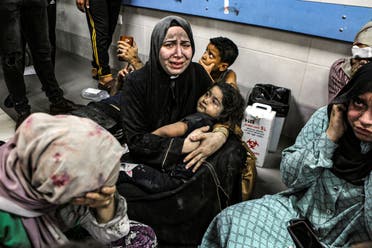 Wounded Palestinians sit in al-Shifa hospital in Gaza City, central Gaza Strip, after arriving from al-Ahli hospital following an explosion there, Tuesday, Oct. 17, 2023. (AP)