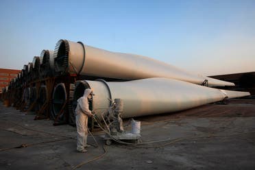 A worker in protective gear stands in front of wind turbines at China Ming Yang Wind Pow-er Zhongshan Ming Yang electric factory in Zhongshan, southern Chinese province of Guangdong. (Reuters)