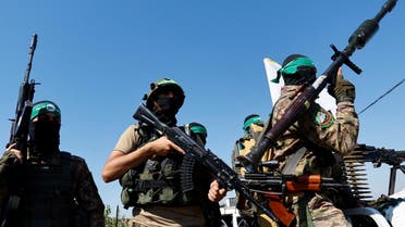 Palestinian fighters from the armed wing of Hamas take part in a military parade to mark the anniversary of the 2014 war with Israel, near the border in the central Gaza Strip, July 19, 2023. (Reuters)