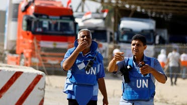 UN workers gesture as trucks carrying aid arrive at the Palestinian side of the border with Egypt, as the conflict between Israel and Palestinian Islamist group Hamas continues, in Rafah in the southern Gaza Strip, October 21, 2023.  (Reuters)