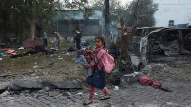 A girl carrying her belongings walks in the area of Al-Ahli hospital where hundreds of Palestinians were killed in a blast that Israeli and Palestinian officials blamed on each other, and where Palestinians who fled their homes were sheltering amid the ongoing conflict with Israel, in Gaza City, October 18, 2023. (Reuters)
