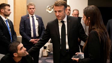 French President Emmanuel Macron (center), meets with Israeli-French nationals who have lost loved ones, as well as families of hostages, at the Ben Gurion airport, on October 24, 2023 in Tel Aviv. (Reuters)