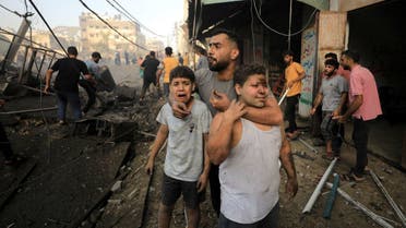 People react as Palestinians search for casualties at the site of an Israeli strike on a residential building in Gaza City, October 25, 2023. (Reuters)