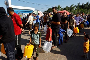 Palestinians, who fled their houses amid Israeli strikes, queue for water in Khan Younis in the southern Gaza Strip, October 26, 2023. (Reuters)