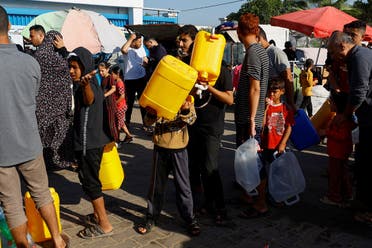 Palestinians, who fled their houses amid Israeli strikes, queue for water as they take shelter at a tent camp at a United Nations-run center, after Israel’s call for more than 1 million civilians in northern Gaza to move south, in Khan Younis in the southern Gaza Strip, on October 26, 2023. (Reuters)