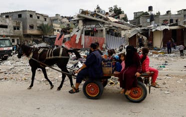 Palestinians ride a horse-drawn wagon next to the site of an Israeli air strike on a house, as the conflict between Israel and Palestinian group Hamas continues, in Khan Younis in the southern Gaza Strip, October 27, 2023. (Reuters)