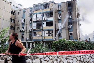 A woman calls out as smoke rises from a residential apartment building where a rocket hit, that was fired from the Gaza Strip towards Israel, in Tel Aviv, Israel, October 27, 2023. (Reuters)
