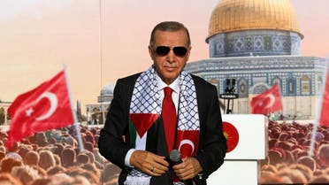 Turkish President Recep Tayyip Erdogan, wearing a scarf with the Palestinian and Turkish flags, stands on the stage during a rally organized by the AKP party in solidarity with the Palestinians in Gaza, in Istanbul on October 28, 2023. (Turkish presidency press office via AFP)