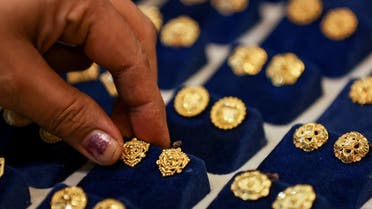 A woman picks a gold earring at a jewellery shop in the old quarters of Delhi, India. (File photo: Reuters)