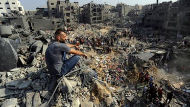 A man sits on the rubble overlooking the debris of buildings that were targeted by Israeli airstrikes in the Jabaliya refugee camp, northern Gaza Strip, Wednesday, Nov. 1, 2023. (AP Photo/Abed Khaled)