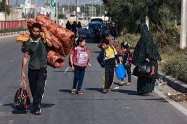 People carrying some of their belongings reach the central Gaza Strip on foot via the Salah al-Din road on their way to the southern part of the Palestinian enclave on November 5, 2023. (AFP)