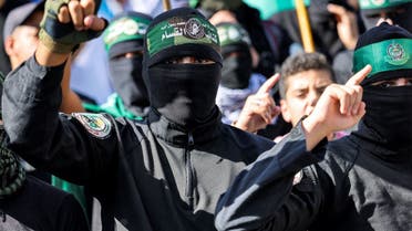 Masked men wearing bandanas showing the name and sigil of the Ezzedine al-Qassam Brigades, the military wing of the Palestinian Hamas movement, take part in a demonstration supporting the Palestinians in Beirut on October 20, 2023, amid the ongoing battles between Israel and Hamas. (AFP)