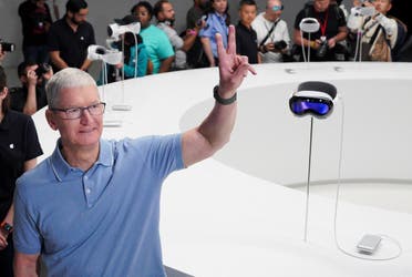 Apple CEO Tim Cook gestures next to Apple’s Vision Pro headsets at Apple’s annual Worldwide Developers Conference at the company's headquarters in Cupertino, Califor-nia, US, on June 5, 2023. (Reuters)
