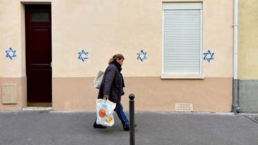 A woman walks past a building tagged with Stars of David in Paris, France, October 31, 2023. (Reuters)