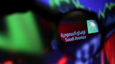 Saudi Aramco logo and stock graph are seen through a magnifier displayed in this illustration. (Reuters)