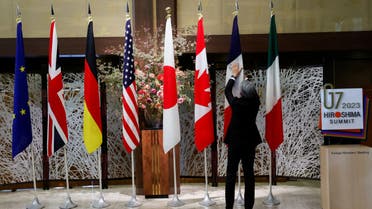 An official adjusts the flags before G7 foreign ministers gather for a family photo during their meetings in Tokyo, Japan, November 8, 2023. (Reuters)