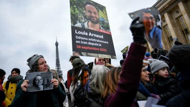 Demonstrators hold portraits of French detainees in Iran Cecile Kohler (L) and Louis Arnaud (C) during a protest in support of French nationals detained by Iranian government, at the “Esplanade du Trocadero” in Paris on January 28, 2023. (AFP)